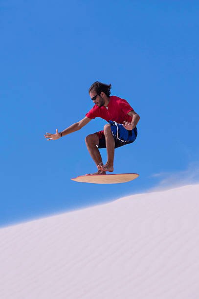 Man boarding on sand dune in Tarifa, Spain