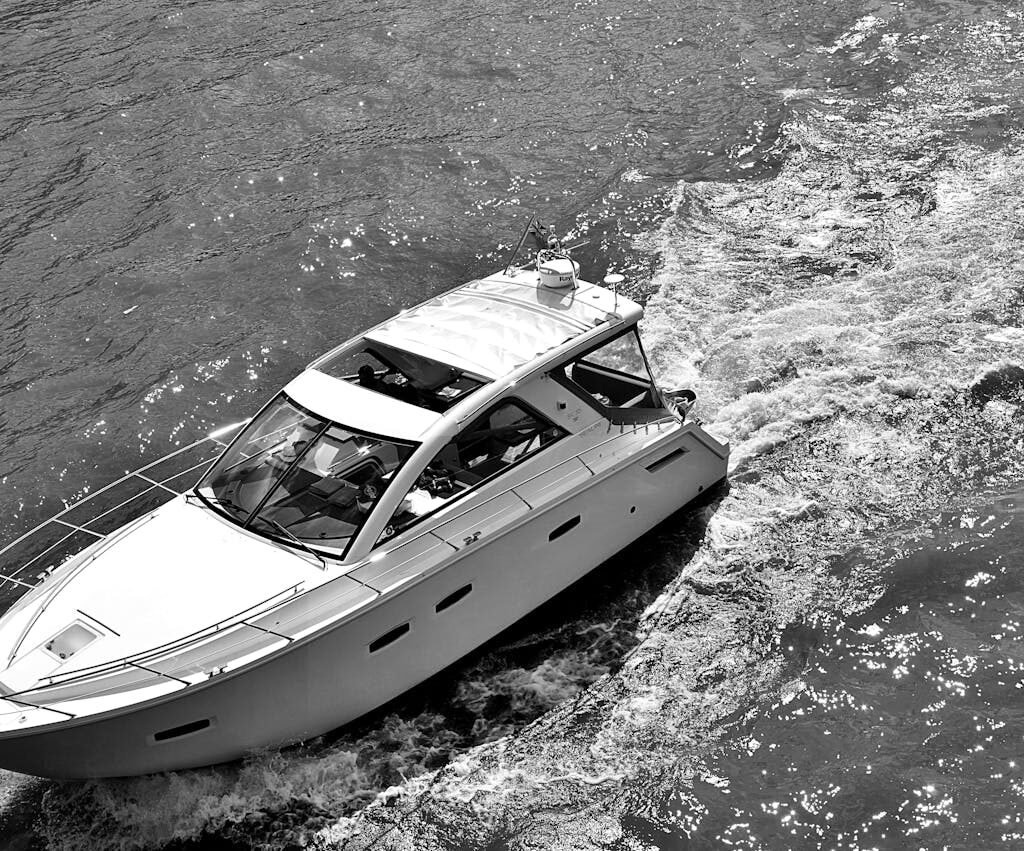 A black and white photo of a yatch sailing on the water in Dubai