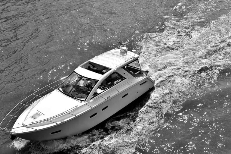 A black and white photo of a yatch sailing on the water in Dubai