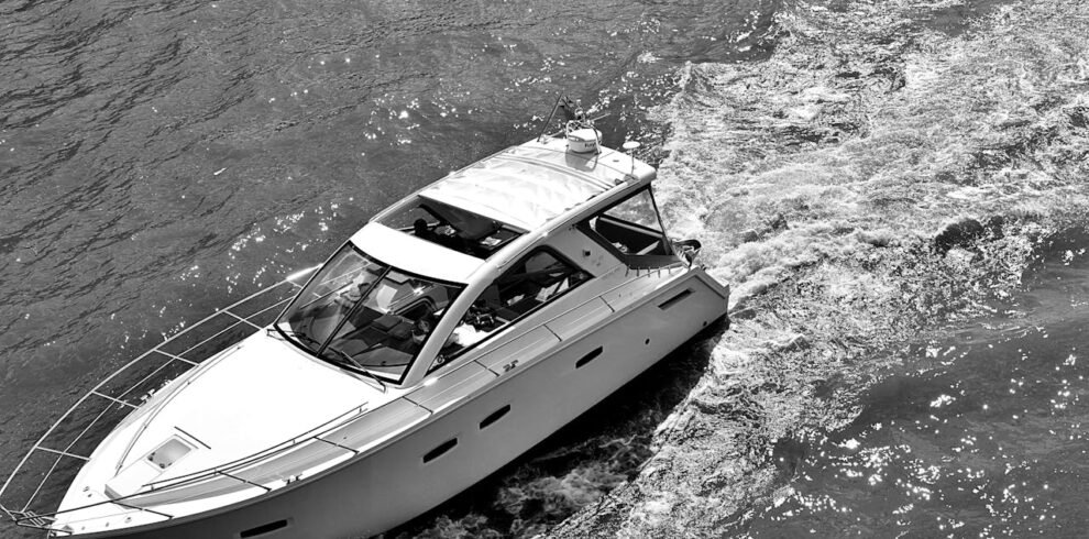 A black and white photo of a yatch sailing on the water in Dubai