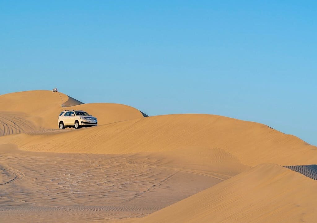 A car driving through the sand dunes in Dubai