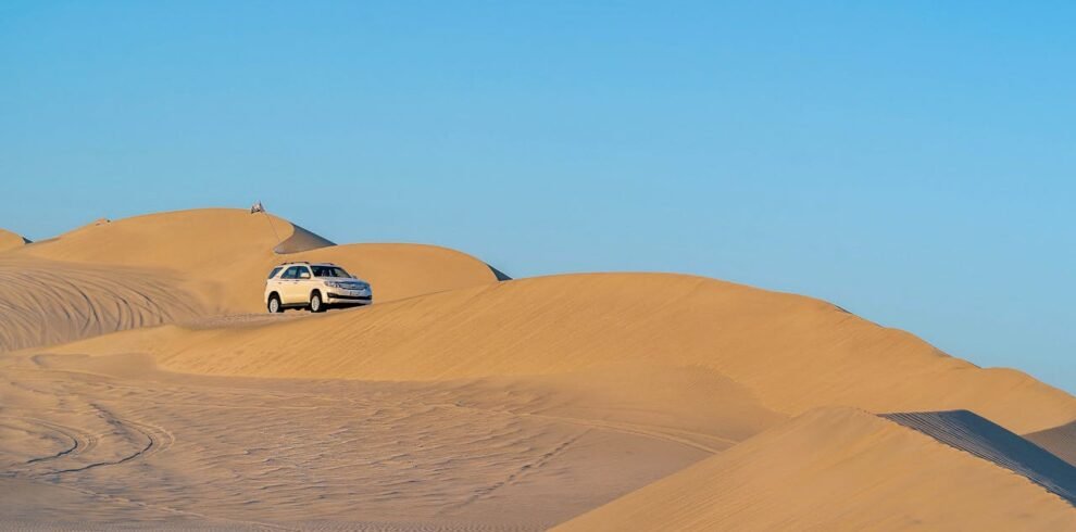 A car driving through the sand dunes in Dubai