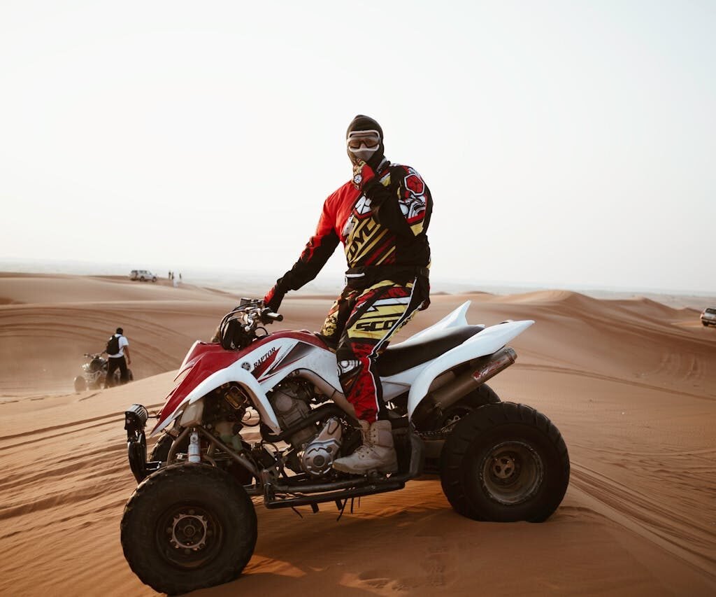 A man riding a quad bike in the desert of Dubai.