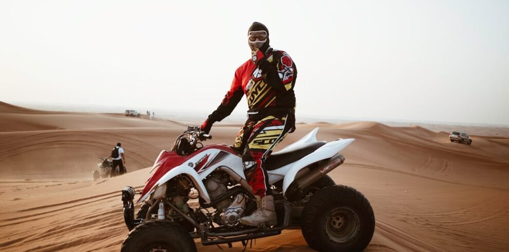 A man riding a quad bike in the desert of Dubai.