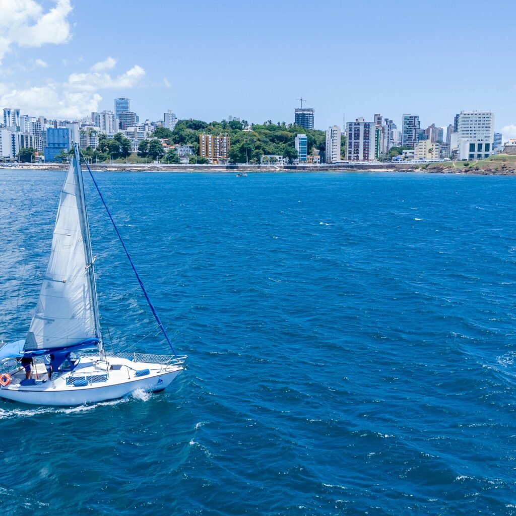 A sailboat in the ocean with Dubai city skyline in the background