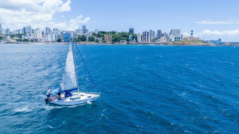 A sailboat in the ocean with Dubai city skyline in the background