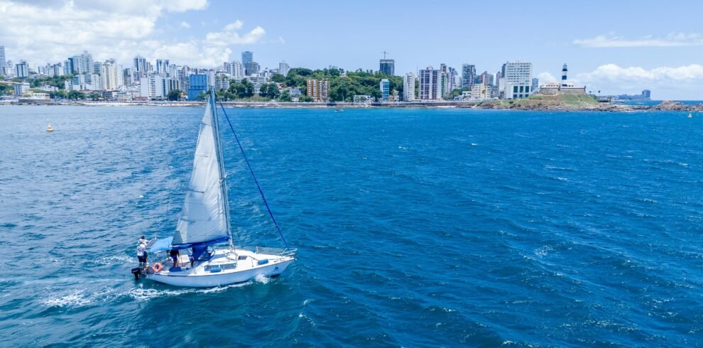 A sailboat in the ocean with Dubai city skyline in the background