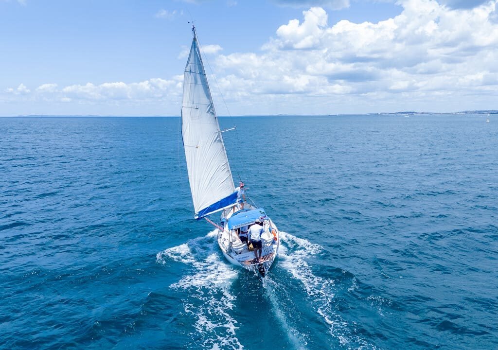 A yacht sailing in the ocean with the city of Dubai in the distance.