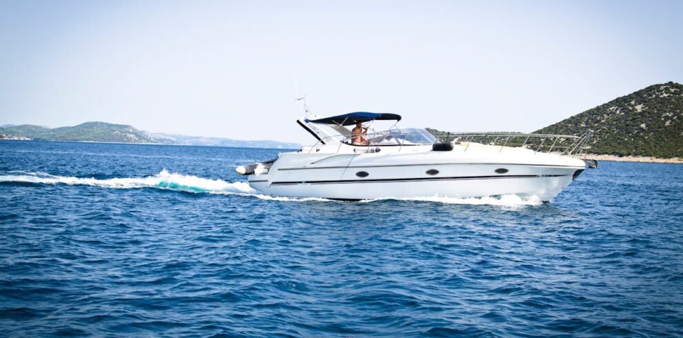 A yacht sailing in the ocean with the city of Dubai in the distance.