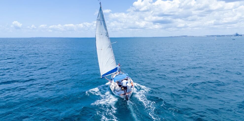 A yacht sailing in the ocean with the city of Dubai in the distance.