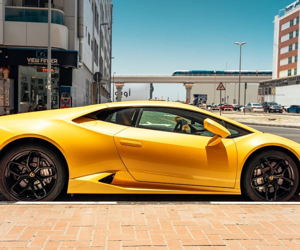 A yellow Lamborghini parked on the side of the road in Dubai.