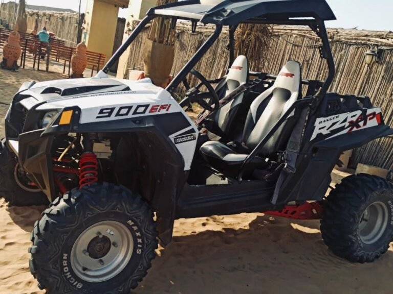 Off-road two seater dung with black tires in Dubai's sandy terrain.