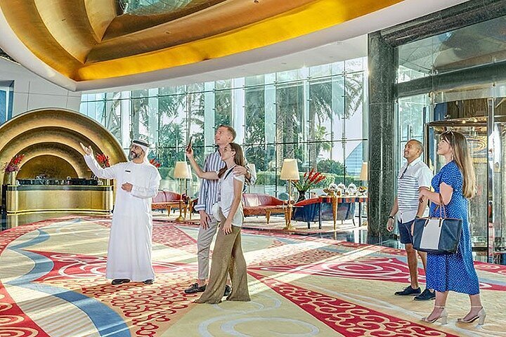 Tourists taking photos in front of hotel lobby at Burj Al Arab Tour.