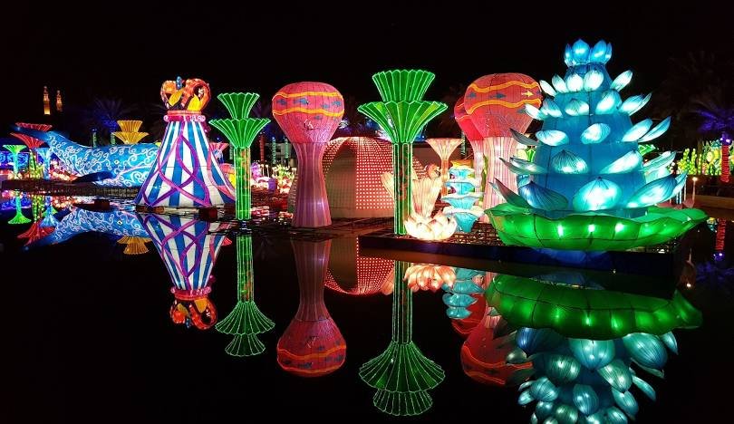 Colorful lights shining in a pond at Dubai Garden Glow.