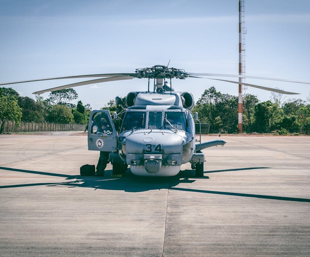 Military helicopter parked on tarmac, part of helicopter tour in Dubai.