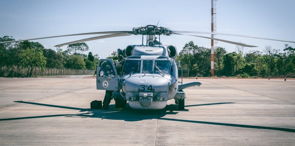 Military helicopter parked on tarmac, part of helicopter tour in Dubai.