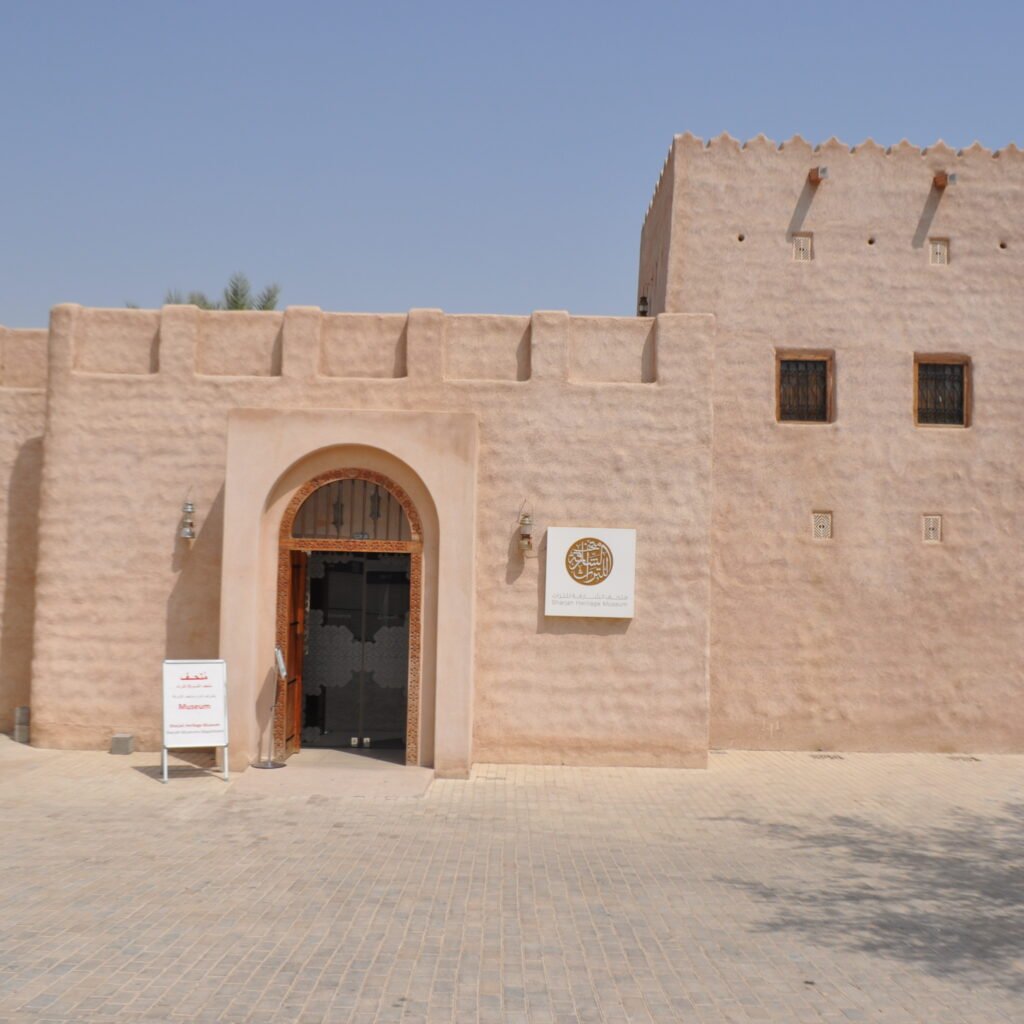 Exterior of Sharjah Heritage Museum, featuring a traditional building with a door.