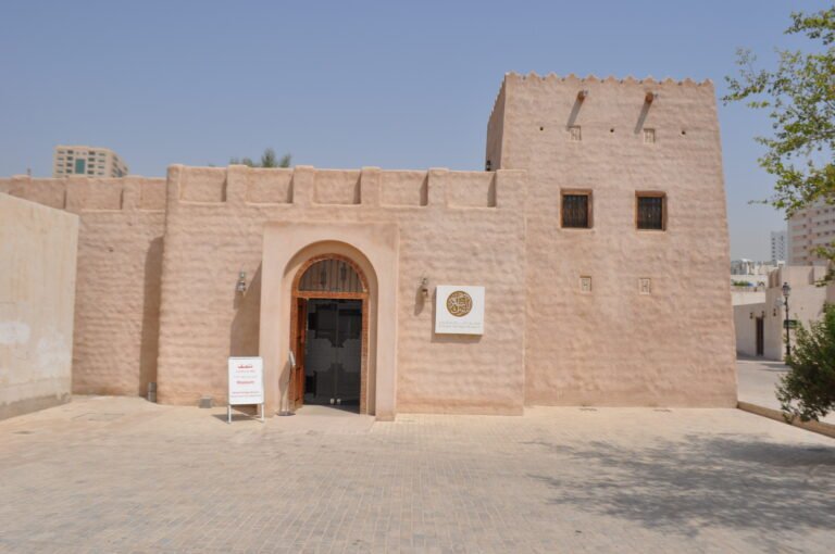 Exterior of Sharjah Heritage Museum, featuring a traditional building with a door.