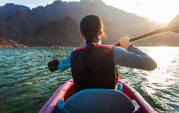 Woman kayaking in scenic Hatta lake in Dubai at sunset