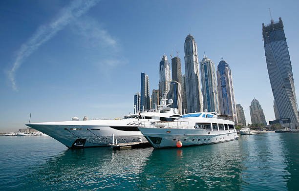 Two super-yachts reflect the abundance of wealth found in modern Dubai, with the tall, modern towers forming an impressive backdrop.