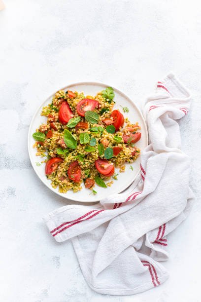 Tabbouleh o tabulè salad, Arab dish from the Middle East and Mediterranean, with parsley, bulgur, onions, mint and tomatoes, seasoned with lemon juice, olive oil, summer vibes, white