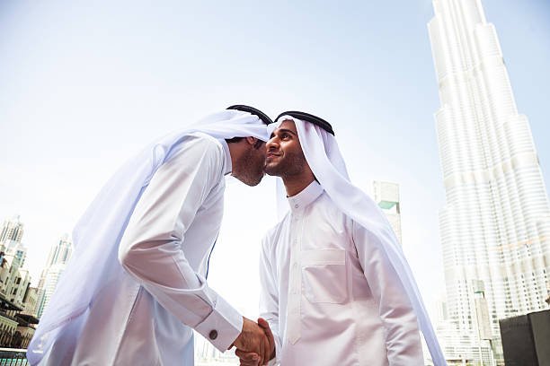 Two emirates business people wearing traditional dish dasha clothing doing business in financial district in Dubai, UAE.