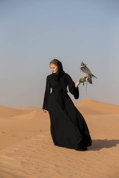 woman in abaya with a peregrine falcon