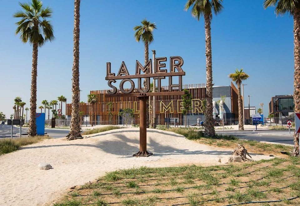 La Mer Beach sign on sandy ground.