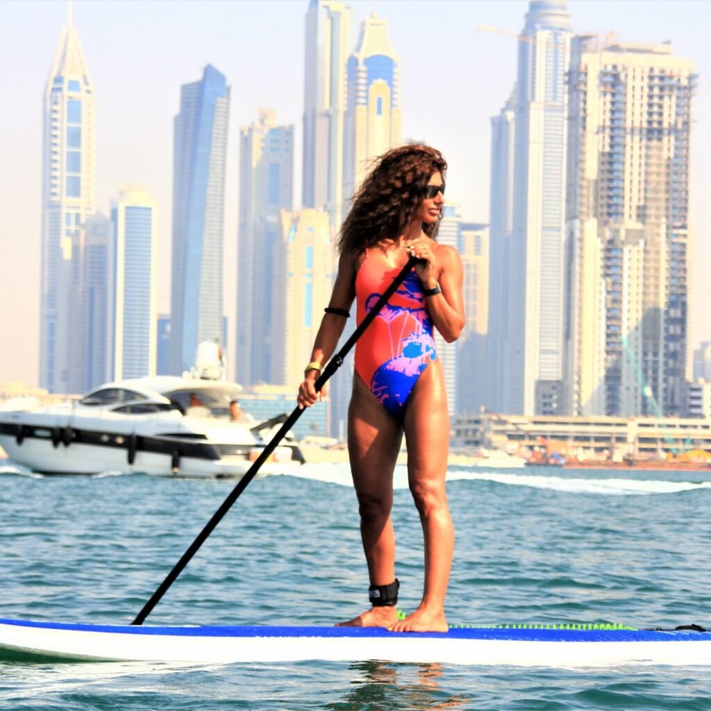  A woman in a bikini paddleboarding on a board.